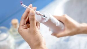 Стаціонарний іригатор для зубів із великим резервуаром та декількома змінними насадками на білому фоні.