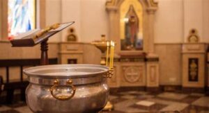 Куми тримають немовля після хрещення в церкві