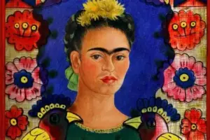 Фріда Кало у яскравому вбранні з квітами у волоссі на тлі зеленого листя