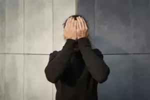 Силует сходів у напівтемряві із фігурою, що стоїть на верхній сходинці — метафора нелегкого підйому та апатії.