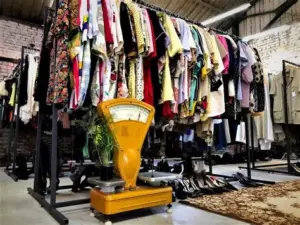 Секонд-хенд магазин з вішалками, заповненими різноманітним одягом — символ доступного та екологічного шопінгу