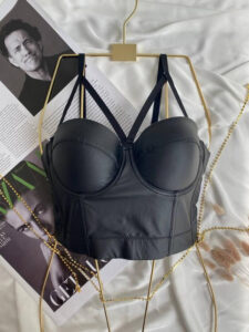 Жінка у легкій білизні стоїть перед дзеркалом, вимірюючи обхват грудей сантиметровою стрічкою