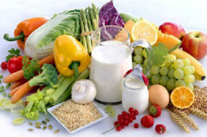 Набір продуктів, багатих кальцієм: сир, молоко, горіхи, броколі та насіння на дерев’яному столі.